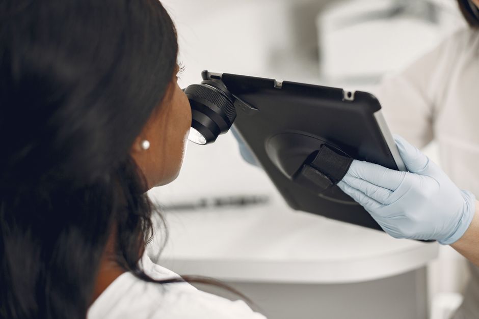 Dermatologist examining a patient's skin with a dermatoscope during a skin cancer screening in Boise.